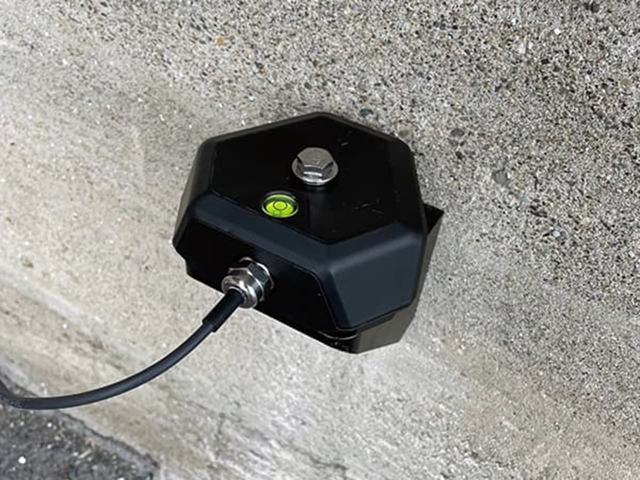 Construction geophone sensor installed on a concrete structure